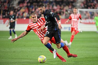 Yannick Carrasco avanza con el balón ante la oposicióon de Oriol Romeu.