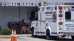 A woman sits outside of Emergency at Coral Gables Hospital where Coronavirus patients are treated in Coral Gables near Miami, on July 30, 2020. - Florida has emerged as a major new epicenter of the US battle against the disease, with confirmed cases recen