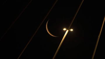 The waning crescent moon, near the end of the Muslim holy month of Ramadan, is pictured behind the Mohammad Baqir al-Sadr bridge in Iraq's southern city of Basra early on April 28, 2022. (Photo by Hussein Faleh / AFP) (Photo by HUSSEIN FALEH/AFP via Getty Images)