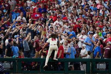 El tercera base de los Philadelphia Phillies, Alec Bohm, intenta alcanzar una bola de foul (que sale fuera del terreno de juego) durante el partido de la serie divisional de la MLB contra los New york Mets. Bohm no dud¨® en poner en peligro su integridad f¨ªsica, subi¨¦ndose a una valla, para coger una pelota bateada por Harrison Bader.
