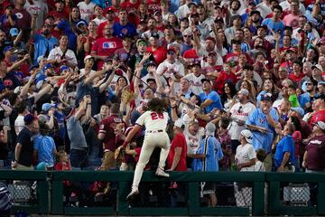 El tercera base de los Philadelphia Phillies, Alec Bohm, intenta alcanzar una bola de foul (que sale fuera del terreno de juego) durante el partido de la serie divisional de la MLB contra los New york Mets. Bohm no dudó en poner en peligro su integridad física, subiéndose a una valla, para coger una pelota bateada por Harrison Bader.