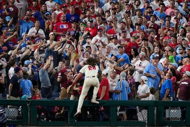 El tercera base de los Philadelphia Phillies, Alec Bohm, intenta alcanzar una bola de foul (que sale fuera del terreno de juego) durante el partido de la serie divisional de la MLB contra los New york Mets. Bohm no dudó en poner en peligro su integridad física, subiéndose a una valla, para coger una pelota bateada por Harrison Bader.