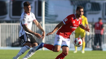 El jugador de Magallanes, Joaquín Larrivey, disputa el balón contra Alan Saldivia de Colo Colo durante el partido de Primera División.