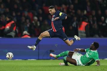 Paris Saint-Germain's Moroccan defender #02 Achraf Hakimi (L) leaps over a challenge from Saint Etienne's Congolese defender #21 Dylan Batubinsika (R) during the French L1 football match between Paris Saint-Germain (PSG) and AS Saint-Etienne at the Parc des Princes Stadium in Paris on January 12, 2025. (Photo by FRANCK FIFE / AFP)