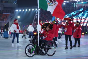 En su silla de ruedas, da la vuelta a todo el estadio mientras ondea orgulloso la bandera tricolor mexicana. 