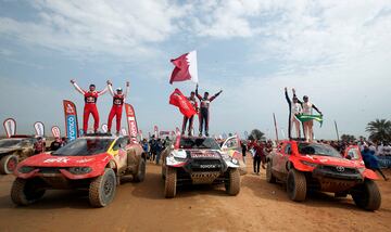 El podio del Dakar en coches. En el medio, los campeones, el piloto catarí Nasser Al-Attiyah y su copiloto, el francés, Mathieu Baumel, a la izquierda, en segundo lugar, el francés Sebastien Loeb y su copiloto Fabian Lurquin, y en tercera posición el piloto brasileño Lucas Moraes y su copiloto, el alemán  Timo Gottschalk.