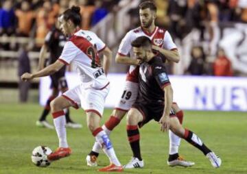 El centrocampista portugués el Rayo Vallecano Luís Carlos Pereira Carneiro controla el balón ante el centrocampista del Granada Francisco Manuel Rico y su compañero, Antonio Amaya
