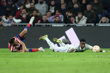 Nahuel Molina y Vinicius Junior ruedan por el césped del Santiago Bernabéu.