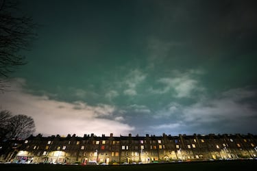 La aurora boreal se ve en el cielo sobre los edificios de viviendas del centro de Edimburgo, Escocia. 