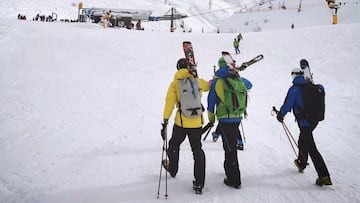 Tres esquiadores camina por la nieve hacia un remonte de la estaci&oacute;n de esqu&iacute; de Ast&uacute;n (valle de Canfranc, Jaca, Pirineo Aragon&eacute;s).