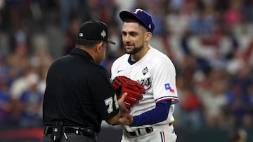 ARLINGTON, TEXAS - OCTOBER 27: Umpire Alfonso Marquez inspects the glove of Nathan Eovaldi #17 of the Texas Rangers in the first inning against the Arizona Diamondbacks during Game One of the World Series at Globe Life Field on October 27, 2023 in Arlington, Texas.   Jamie Squire/Getty Images/AFP (Photo by JAMIE SQUIRE / GETTY IMAGES NORTH AMERICA / Getty Images via AFP)