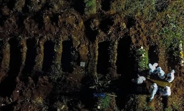 Aerial view showing a coffin being buried at the Vila Formosa cemetery in Sao Paulo, Brazil, on March 31, 2021, amid the novel coronavirus COVID-19 pandemic. - Brazil closed out its deadliest month of the coronavirus pandemic by far on Wednesday as a surge of COVID-19 patients overwhelmed hospitals, forcing doctors to make agonizing decisions over whom to give life-saving care. (Photo by Miguel SCHINCARIOL / AFP)