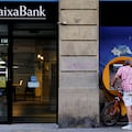 FILE PHOTO: A man uses a Caixabank ATM in Barcelona