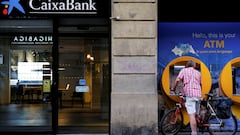 FILE PHOTO: A man uses a Caixabank ATM in Barcelona, Spain, October 3, 2022. REUTERS/Nacho Doce/File Photo
