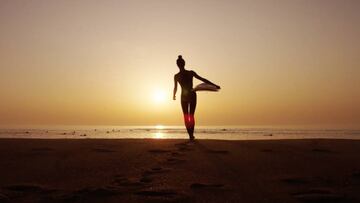 Victoria Vergara en plena puesta de sol con su tabla de surf.