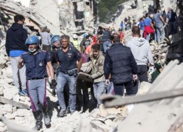 ITA66 AMATRICE (ITALIA) 24/08/2016.- Un hombre herido (c) es rescatado por los equipos de emergencia en Amatrice, en el centro de Italia, hoy, 24 de agosto de 2016. Al menos 38 personas han muerto y decenas se encuentran desaparecidas a causa del terremoto de 6,0 grados de magnitud en la escala abierta de Richter que ha sacudido el centro de Italia en la madrugada de hoy, informó la Protección Civil italiana. EFE/Massimo Percossi