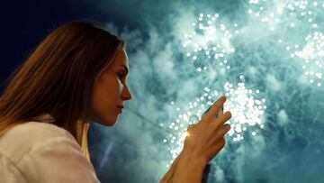 Saint Petersburg (Russian Federation), 24/06/2018.- A woman takes pictures of fireworks shot over the Neva River during Scarlet Sails celebration in St. Petersburg, Russia, early 24 June 2018. A frigate with scarlet sails participates in festivities marki