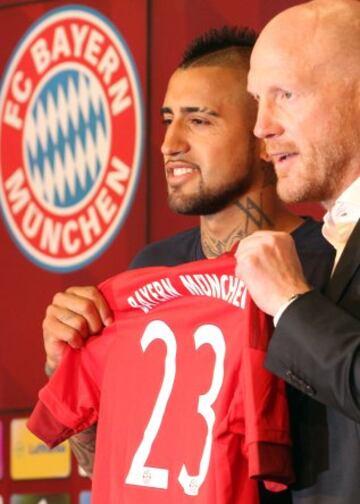 Arturo Vidal posa con su nueva camiseta del Bayern Munich junto al director deportivo del club, Matthias Sammer.