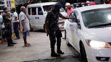 A Sri Lanka Air Force member checks the tokens of people queueing for fuel due to fuel shortage, amid the country's economic crisis, in Colombo, Sri Lanka, June 27, 2022. REUTERS/Dinuka Liyanawatte