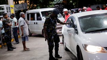 A Sri Lanka Air Force member checks the tokens of people queueing for fuel due to fuel shortage, amid the country's economic crisis, in Colombo, Sri Lanka, June 27, 2022. REUTERS/Dinuka Liyanawatte