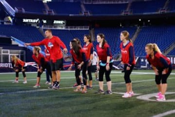 Rob Gronkowski enseña los fundamentos del fútbol americano a un grupo de mujeres.