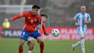Chile's forward #09 Damian Pizarro and Argentina's midfielder #17 Valentino Acu�a fight for the ball during the 2025 South American U-20 football championship final round match between Chile and Argentina at the UCV Olympic stadium in Caracas on February 4, 2025. (Photo by JUAN BARRETO / AFP)
