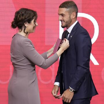 El capitán del Atlético de Madrid, Koke Resurrección, recibe la Gran Cruz de la Orden del Dos de Mayo de manos de la presidenta de la Comunidad de Madrid, Isabel Diaz Ayuso.  