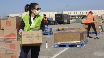 April 15, 2020 - Austin, Texas, United States: Central Texas Food Bank volunteers work to load 28-pound boxes of staples into vehicles during a food giveaway in east Austin. Almost 2,500 families picked up boxes in response to extensive coronavirus pandem