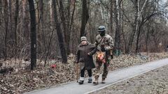 Un soldado ayuda a camina a una anciana bajo el bombardeo, a 6 de marzo de 2022, en Irpin (Ucrania).