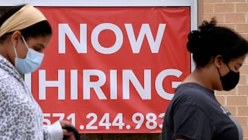 (ARCHIVOS) En esta foto de archivo tomada el 16 de agosto de 2021, las mujeres pasan junto a un letrero que dice &quot;Ahora contratando&quot; afuera de una tienda en Arlington, Virginia. 