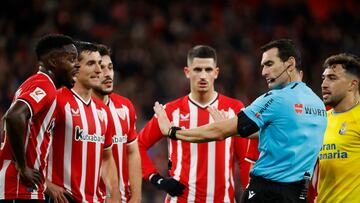 BILBAO, 20/12/2023.- El árbitro Martínez Munuera pide calma a los jugadores ante un posible penalti, durante el encuentro de la jornada 18 de LaLiga entre Athletic Club de Bilbao y UD Las Palmas, este miércoles en el estadio de San Mamés, en Bilbao. EFE/ Luis Tejido
