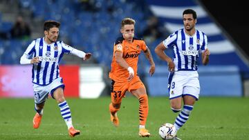 SAN SEBASTIAN, SPAIN - SEPTEMBER 29: Alex Blanco of Valencia CF runs with the ball under pressure from David Silva and Mikel Merino of Real Sociedad during the La Liga Santander match between Real Sociedad and Valencia CF at Estadio Anoeta on September 29