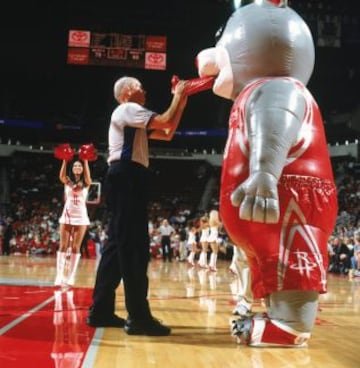 Dick Bavetta, mítico entrenador de la NBA, introduce un plástico en la boca de la mascota de los Houston Rockets.