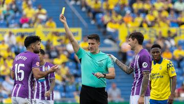 LAS PALMAS DE GRAN CANARIA, 07/12/2024.- El árbitro del encuentro Díaz de Mera (c) saca tarjeta amarilla al suizo Eray Cömert (i) del Real Valladolid, durante el partido correspondiente a la jornada décimo sexta de LaLiga EA Sports que disputan este sábado Estadio de Gran Canaria.EFE/Quique Curbelo