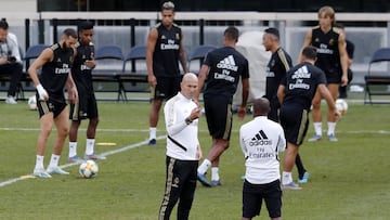 Zidane en un entrenamiento con el equipo tocando bal&oacute;n al fondo.
 