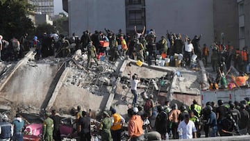 Cuerpos de emergencia y voluntarios ayudan en las labores de rescate de un edificio derrumbado por el sismo en M&eacute;xico.