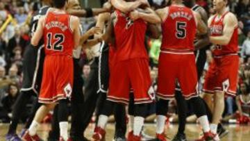 Joakim Noah controla a su compa&ntilde;ero Jimmy Butler durante un altercado con el jugador de Nets Joe Johnson.