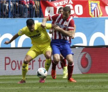 Cani (i) disputa un balón con el centrocampista del Atlético de Madrid Mario Suárez (d).