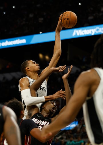 Victor Wembanyama sobrevuela encima del jugador de los Miami Heat, Thomas Bryant.