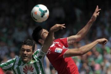 El jugador del Betis Jorge Molina (i), Víctor Machín, del Sevilla F.C., luchan por el balón en una jugada durante el partido de Liga que los dos equipos han disputado hoy en el estadio Benito Villamarín de Sevilla. 