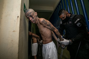 Un agente del Centro de Confinamiento del Terrorismo esposa a un preso.