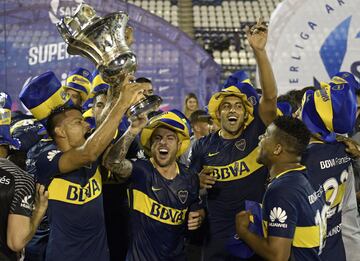 Boca Juniors' footballers (L-R) foward Walter Bou holds the trophy next to teammates defender Julio Buffarini, foward Ramon Abila and Colombian defender Frank Fabra celebrating winning the Argentina First Division Superliga championship after a tie 2-2 with Gimnasia y Esgrima La Plata at Juan Carmelo Zerillo stadium in La Plata, Buenos Aires, Argentina, on May 9, 2018. / AFP PHOTO / JUAN MABROMATA