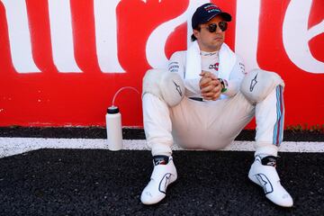 Felipe Massa, sentado en el suelo, espera el inicio de la carrera. 