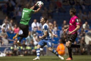 El guardamenta de la UD Almería, Estaban,iz., coge el balón ante Pizzi,c., del RCD Espanyol, durante el partido entre ambos conjuntos, correspondiente a la 35ª jornada de Liga BBVA, disputado esta mañana en Cornellá-El Prat.