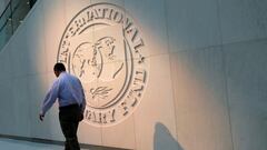 FILE PHOTO: A man walks past the International Monetary Fund (IMF) logo at its headquarters in Washington, U.S., May 10, 2018. REUTERS/Yuri Gripas/File Photo