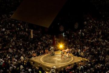 Dos luchadores compiten durante el Gran Torneo de Sumo en el Ryogoku Kokugikan.