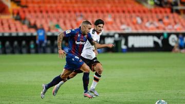 Roger Mart&iacute; pugna por el bal&oacute;n con Guedes en un Mestalla vac&iacute;o.