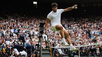 Spain's Carlos Alcaraz jumps to kick a ball as he celebrates beating Serbia's Novak Djokovic during their men's singles final tennis match on the last day of the 2023 Wimbledon Championships at The All England Tennis Club in Wimbledon, southwest London, on July 16, 2023. (Photo by Adrian DENNIS / AFP) / RESTRICTED TO EDITORIAL USE