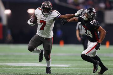 The Tampa Bay Buccaneers' Leonard Fournette (left) holds off A.J. Terrell of the Atlanta Falcons.