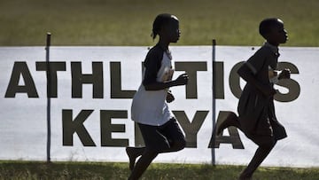 Junior athletes run past a sign for Athletics Kenya.  